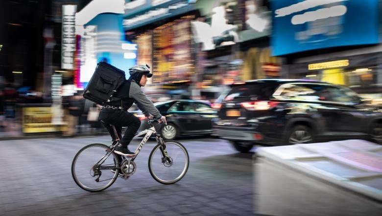 Coursier à vélo dans une avenue